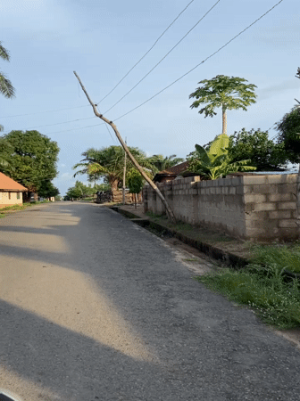 Vehicle travels worn paved road in Mararaba, Nigeria