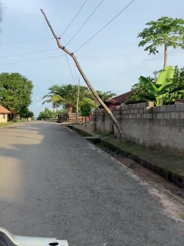 Vehicle travels worn paved road in Mararaba, Nigeria