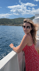 Woman in red dress enjoys boat ride near Lepetane, Montenegro