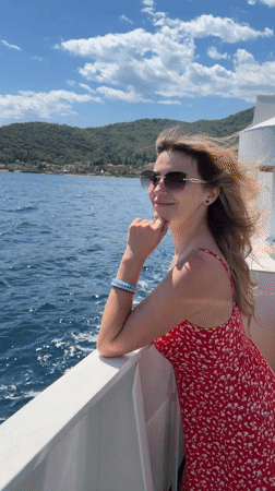 Woman in red dress enjoys boat ride near Lepetane, Montenegro