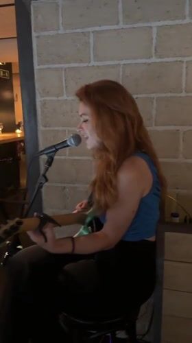 Live solo guitar performance in a Barcelona brick-wall venue