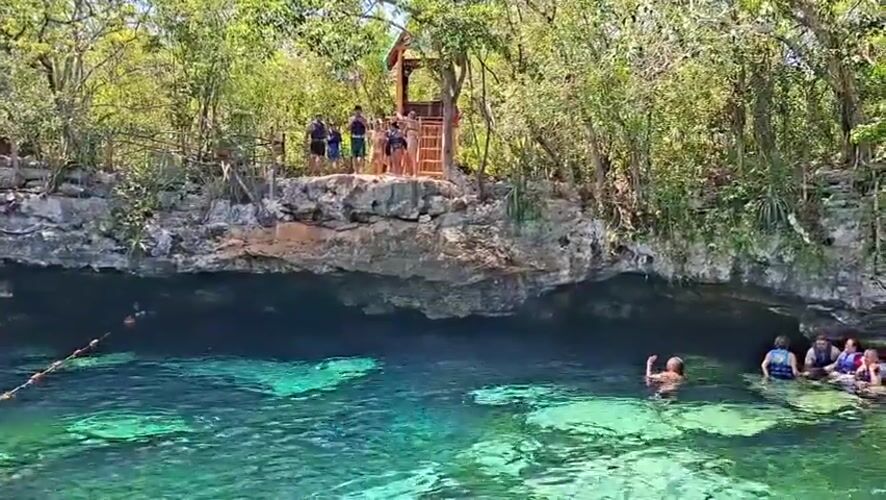Tourists enjoy swimming at Mexican cenote near Ciudad Aventuras