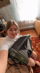Woman with green accordion spotted in vintage room