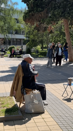 Accordion player performs in Lovech plaza amid scenic Bulgarian town views