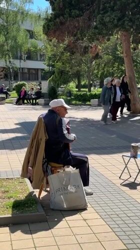 Accordion player performs in Lovech plaza amid scenic Bulgarian town views