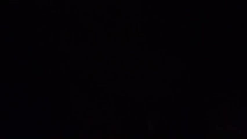 The video is extremely dark and grainy, making it difficult to discern any specific details. It appears to be a very low-light environment, possibly indoors. The footage is shaky and the camera is in motion. There are indistinct shapes and shadows visible, but no clear human figures, objects, or actions can be identified. The overall impression is one of obscurity and a lack of discernible information.
