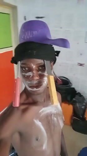 Street performer with white face paint documented in Akwete
