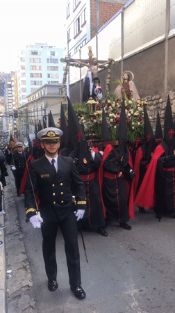 Religious procession with hooded participants moves through La Paz streets