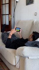 Man plays PlayStation Vita on sofa in Gijón
