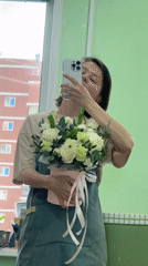 Woman documents flower shop selfies with bouquet in Izhevsk