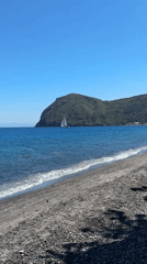 Sailboat glides across turquoise waters near Lipari, Italy