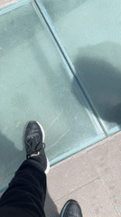 Visitors gather at Spanish ocean viewpoint with glass barriers