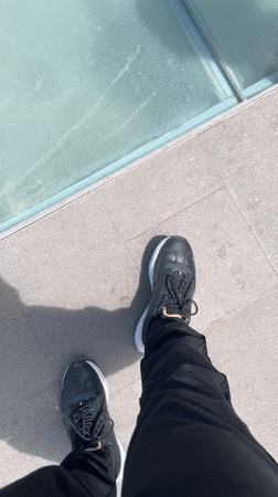 Visitors gather at Spanish ocean viewpoint with glass barriers