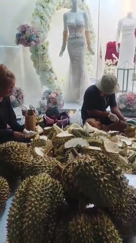Durian vendors process fruit on Thailand street at night