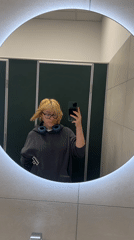 Young person takes mirror selfie in Chișinău public restroom
