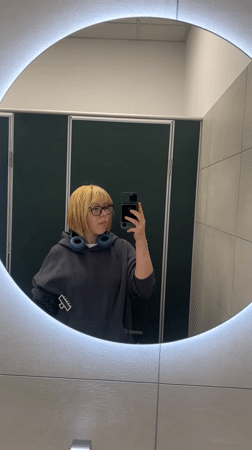 Young person takes mirror selfie in Chișinău public restroom
