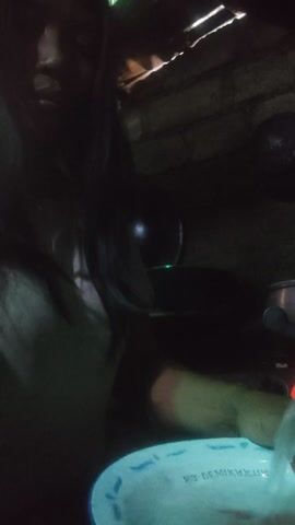 This media file captures a close-up, low-angle view of a person's arm and hand interacting with what appears to be a water-filled container. The setting is dark, illuminated by artificial light sources, suggesting an indoor environment or nighttime outdoor setting. The arm is positioned from the left side of the frame, with the hand submerged in water. A blue object, possibly a bowl or a cup with text partially visible, is held by the hand. The text on the blue object appears to read "DEMIRAH." In the background, there are dark, indistinct shapes, including what could be hair or fabric, and a rough, textured surface that might be wood or stone. A green light source is also visible. The overall impression is one of a personal, perhaps domestic, activity involving water. The darkness and the close cropping of the shot create a somewhat intimate and mysterious atmosphere. The focus is primarily on the interaction between the hand and the water, with a hint of the surrounding environment. The date stamp at the beginning of the media file indicates it was recorded on 23/07/2019 at 09:50:23.