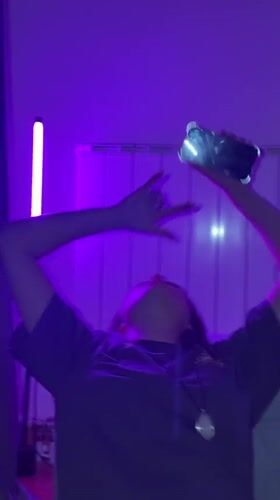 Purple-lit gathering captured on phones in Belgrade room