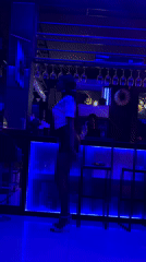 Woman dances at blue-lit nightclub in Accra