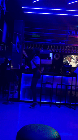 Woman dances at blue-lit nightclub in Accra