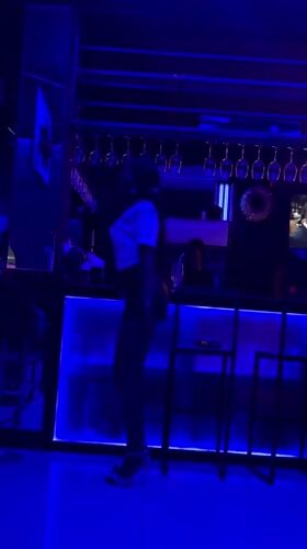 Woman dances at blue-lit nightclub in Accra