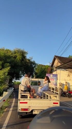 Passengers ride in pickup truck bed in Abang, Indonesia