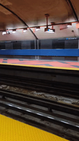 Quiet subway platform with yellow edge strip and patterned tile