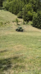 Woman documents tractor mowing field in Austrian countryside