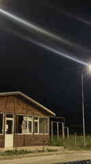 Nighttime footage captures wooden building under streetlights