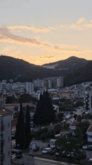 Witness records dusk cityscape through curtain on May 20