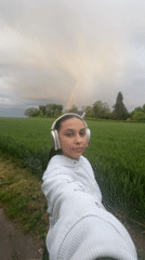 Woman documents rainbow over Mönchengladbach fields during evening walk