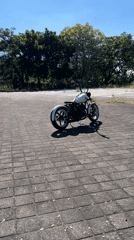 White custom motorcycle parked, rider poses in full gear