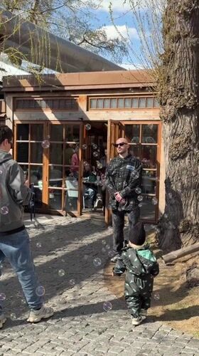Man blows bubbles for toddler outside Moscow building