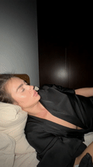 Woman rests in bedroom with phone, Warsaw evening