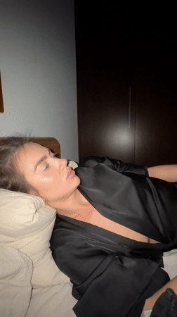 Woman rests in bedroom with phone, Warsaw evening