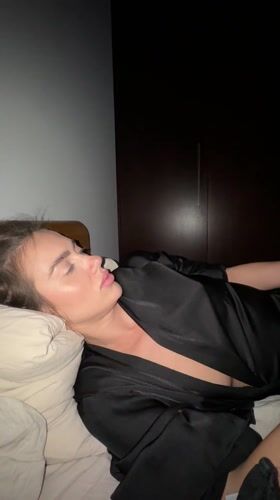 Woman rests in bedroom with phone, Warsaw evening