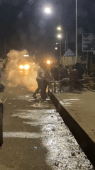 Emergency van and street activity on a wet Bukuru night