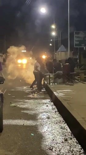 Emergency van and street activity on a wet Bukuru night