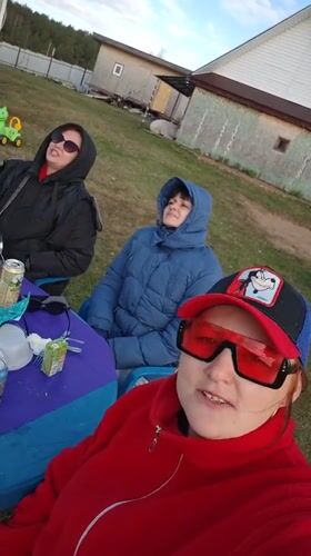 Three women gather at outdoor table in Markovo