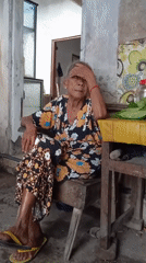 Elderly woman cooks and rests in Baron, Indonesia