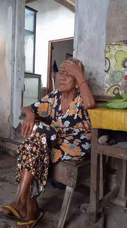 Elderly woman cooks and rests in Baron, Indonesia