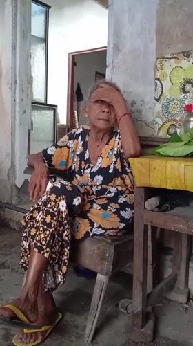 Elderly woman cooks and rests in Baron, Indonesia