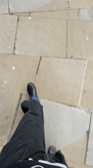 Person walks along stone sidewalk in London morning