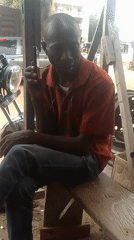 Man makes phone call from workshop bench in Adankolo