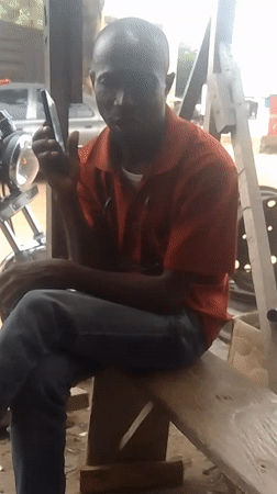 Man makes phone call from workshop bench in Adankolo