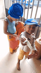 Two kids playing together, umbrella in hand