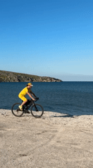Cyclist in yellow rides beach in Ukraine coastal area