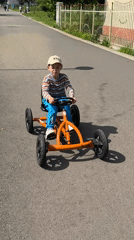 Children play at sunny Burgas playground with karts and swings