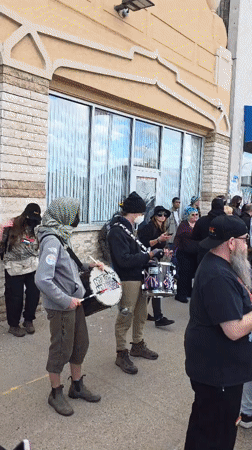 Street protest with drums, signs outside Hamtramck mosque