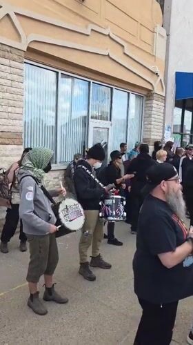 Street protest with drums, signs outside Hamtramck mosque